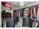 Spacious walk-in closet with custom shelving, hanging rods, drawers and stylish light fixture at 802 Towering Pine Trl, Lawrenceville, GA 30045