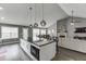 Open-concept kitchen with a large island, stylish lighting, and seamless flow to the living area at 802 Towering Pine Trl, Lawrenceville, GA 30045