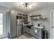 Modern kitchenette featuring gray cabinets, stainless steel appliances, and open shelving at 802 Towering Pine Trl, Lawrenceville, GA 30045