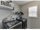 A bright laundry room is equipped with new front-load machines, shelves, and natural light at 802 Towering Pine Trl, Lawrenceville, GA 30045