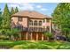 Exterior of home showcasing a brick facade, large windows, deck, and a manicured green lawn at 1483 Jones Rd, Roswell, GA 30075
