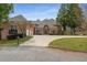 Stately brick home with a circular driveway, mature trees and three-car garage at 1483 Jones Rd, Roswell, GA 30075