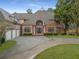 Front exterior featuring an arched entryway, columns, three-car garage, and a circular driveway at 1483 Jones Rd, Roswell, GA 30075