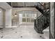 Grand foyer featuring tile floors, staircase, stone columns, and a wall of windows at 1483 Jones Rd, Roswell, GA 30075