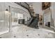 Open foyer with stone-look accents, marble flooring and a grand staircase at 1483 Jones Rd, Roswell, GA 30075