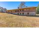 Rear view of a brick home with a stone foundation, featuring a partially finished basement and ample backyard space at 9095 Cedar Grove Rd, Fairburn, GA 30213