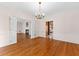 Elegant dining room featuring hardwood floors, chandelier, and an easy transition to the living room and kitchen at 9095 Cedar Grove Rd, Fairburn, GA 30213