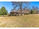 Charming single-story home with a well-maintained lawn and mature trees, set against a clear blue sky at 9095 Cedar Grove Rd, Fairburn, GA 30213