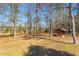 Scenic landscape showcasing a wooded area with a quaint outbuilding and a rustic pavilion at 9095 Cedar Grove Rd, Fairburn, GA 30213