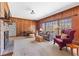 Spacious living room features brick fireplace, wood paneling, and large windows at 9095 Cedar Grove Rd, Fairburn, GA 30213