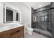 Modern bathroom with wood vanity, a light up mirror, and glass enclosed shower with dark tile at 942 Fairfield Dr, Marietta, GA 30068