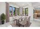 Staged dining room with large black frame windows, a neutral table setting, and modern accents at 942 Fairfield Dr, Marietta, GA 30068