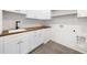 Bright laundry room with white cabinetry, wood countertop, and a sleek black faucet at 942 Fairfield Dr, Marietta, GA 30068
