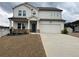 Charming two-story home with a two-car garage, inviting porch, and manicured lawn on an overcast day at 14 Ledgemont Way, Acworth, GA 30101