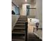 Dark wood staircase leading down to a kitchen with white countertops at 14 Ledgemont Way, Acworth, GA 30101