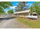 Home exterior with a large propane tank and gravel driveway, surrounded by mature trees at 24 Allatoona Landing Rd #29, Cartersville, GA 30121