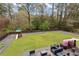 A large flat grassy yard offers play space and outdoor enjoyment, with patio, seating, and a modern horizontal fence at 3473 Regalwoods Dr, Atlanta, GA 30340