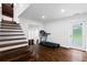 Basement area with wooden staircase, sleek metal railing, hardwood floors, and exercise equipment at 3473 Regalwoods Dr, Atlanta, GA 30340