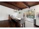 Dining room featuring a wood dining table, exposed wood beams, and access to the outdoor deck at 3473 Regalwoods Dr, Atlanta, GA 30340