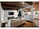 Cozy living room featuring a brick fireplace, wood ceiling beams, and modern decor open to a kitchen at 3473 Regalwoods Dr, Atlanta, GA 30340