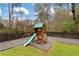 Backyard play structure for with a slide, climbing wall, and swing, bordered by a dark horizontal fence at 3473 Regalwoods Dr, Atlanta, GA 30340