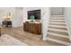 Inviting entryway with wood-look floors, accent table, mounted TV, and staircase at 604 Blue Sky Blvd, Acworth, GA 30102