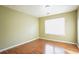 Empty bedroom with wood floors, a window, neutral walls, and modern design at 4033 Roxberry Hill Ln, Buford, GA 30518