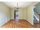 Spacious dining room featuring wood floors, a chandelier, and seamless transition to the kitchen and living areas at 4033 Roxberry Hill Ln, Buford, GA 30518