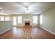 Empty living room features a fireplace, wood floors, and natural light from the windows at 4033 Roxberry Hill Ln, Buford, GA 30518