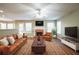 Staged living room with brick fireplace, leather furniture, and a ceiling fan for added comfort at 4033 Roxberry Hill Ln, Buford, GA 30518