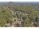 High aerial view of multiple homes nestled among dense trees, with rolling hills in the background at 4950 Luke Dr, Cumming, GA 30040