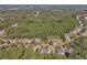 Extensive aerial shot captures homes in a wooded neighborhood near a highway, set against a lush green backdrop at 4950 Luke Dr, Cumming, GA 30040