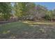 Expansive backyard with a lush lawn, surrounded by trees and landscaping at 4950 Luke Dr, Cumming, GA 30040