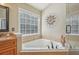 Bathroom with a corner bathtub, tiled walls, and decorative artwork at 4950 Luke Dr, Cumming, GA 30040