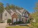 Traditional two-story home with a brick and siding facade, enhanced by lush landscaping at 4950 Luke Dr, Cumming, GA 30040
