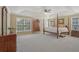 This primary bedroom boasts a tray ceiling, four-poster bed, and neutral carpeting at 4950 Luke Dr, Cumming, GA 30040
