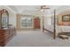 Large primary bedroom with neutral decor, four-poster bed, and ample dresser space at 4950 Luke Dr, Cumming, GA 30040