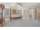 Spacious primary bedroom with tray ceiling, four-poster bed, and adjoining bathroom at 4950 Luke Dr, Cumming, GA 30040