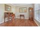 Office with wood flooring, antique desk, wall mirror, and grandfather clock at 4950 Luke Dr, Cumming, GA 30040