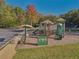 A well-equipped playground in a community park, featuring slides, climbing structures, and a cushioned ground surface at 4950 Luke Dr, Cumming, GA 30040