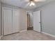 Neutral bedroom featuring tile floors, a ceiling fan, and a double-door closet for ample storage at 2220 Golden Valley Dr, Lawrenceville, GA 30043