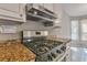 A kitchen showcases a gas range, a stainless steel hood, granite countertops, and abundant natural light at 2220 Golden Valley Dr, Lawrenceville, GA 30043