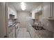 Galley kitchen featuring white cabinets, stone countertops, and matching white appliances at 37 Le Parc Fontaine, Lithonia, GA 30038