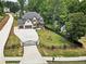 Aerial view showcasing a beautiful home with a manicured front yard and long driveway at 1930 Collins Hill Rd, Lawrenceville, GA 30043