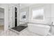 Bathroom with soaking tub, glass enclosed shower, and marble floors at 1930 Collins Hill Rd, Lawrenceville, GA 30043