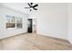 Bedroom with modern ceiling fan, wood floors, and sleek black door at 1930 Collins Hill Rd, Lawrenceville, GA 30043