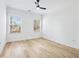 Bright, spacious bedroom with wood flooring, ceiling fan, and natural light from two windows at 1930 Collins Hill Rd, Lawrenceville, GA 30043