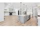 Modern kitchen features an island, stainless steel appliances, and an open floor plan with a fireplace in the living area at 1930 Collins Hill Rd, Lawrenceville, GA 30043