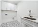 Bright laundry room with stylish tile floor, cabinets, and a stainless steel sink at 1930 Collins Hill Rd, Lawrenceville, GA 30043