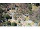 An aerial view displays multiple homes nestled among trees on a spacious, wooded lot in a charming residential neighborhood at 380 Hidden Valley Sw Dr, Conyers, GA 30094